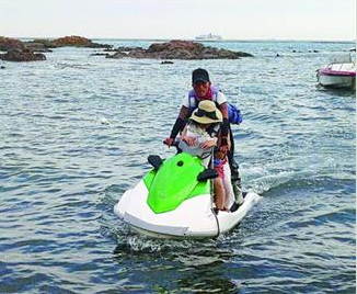 潮水上涨游客被困礁石 志愿者驾摩托艇营救