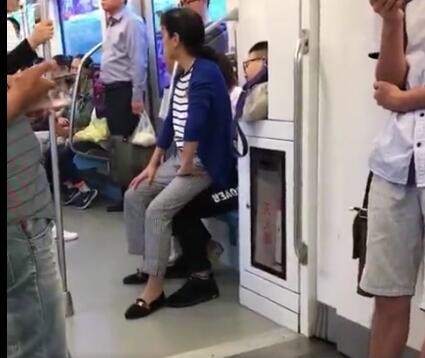 地铁上一小伙不肯让座 大妈直接坐到了他腿上