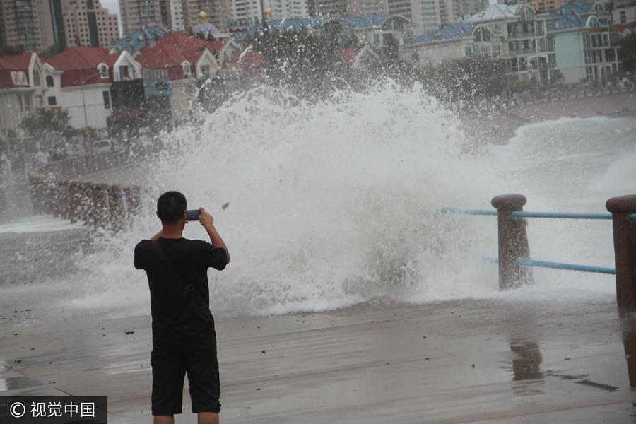 青岛国庆首日遇狂风 游客海边观潮捡海带