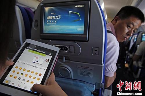 资料图为旅客在东航实际承运的航班上使用平板电脑（Pad），进行空地互联微信聊天。 <a target='_blank' href='中新社</a>记者殷立勤摄
