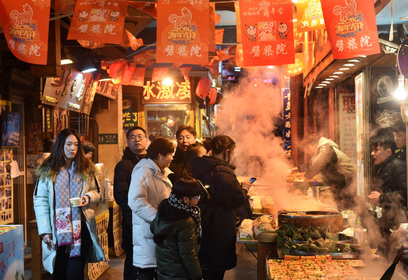 游客在青岛的特色小吃街劈柴院品尝美食(2月17日摄).