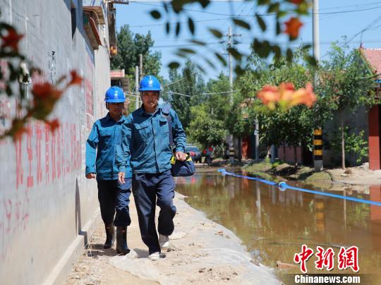 8月25日，寿光电力部门工作人员正赶赴受灾区，对电力装置进行维护。　沙见龙摄