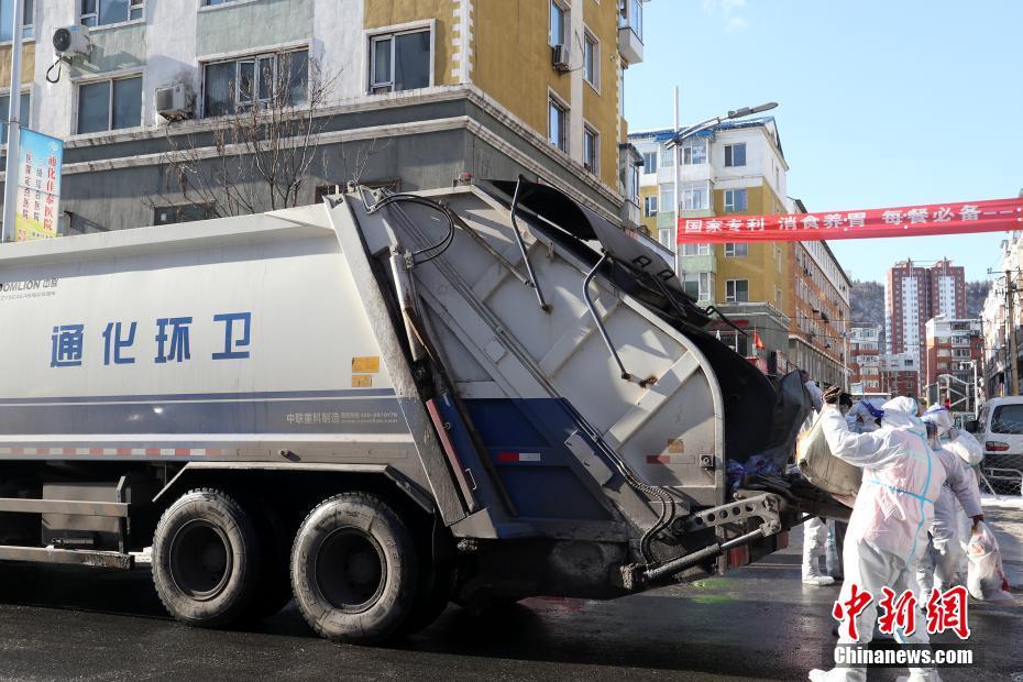 环卫工人将收取的垃圾倒入垃圾车.