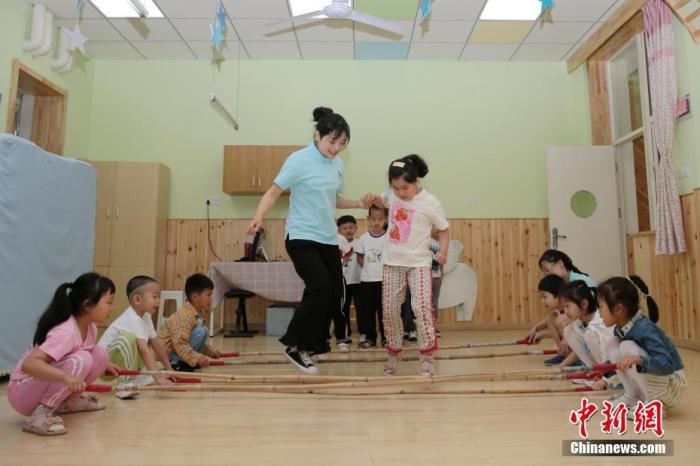 资料图：老师带领孩子们在教室内游戏。<a target='_blank' href='http://www.chinanews.com/'>中新社</a>记者张远摄