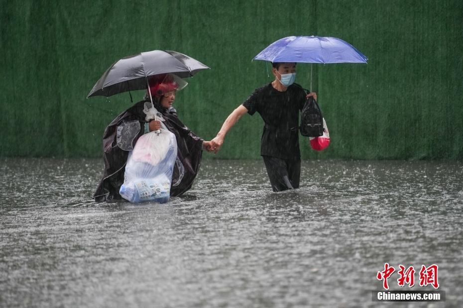 7月11日，山西省太原市，市民淌水经过一处积水路段。<a target='_blank' href='/'>中新社</a>记者武俊杰摄