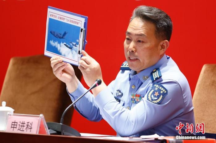 图为申进科大校在发布会上展示运油-20、歼-20、歼-16三机同框照。 <a target='_blank' href='/'>中新社</a>记者富田摄