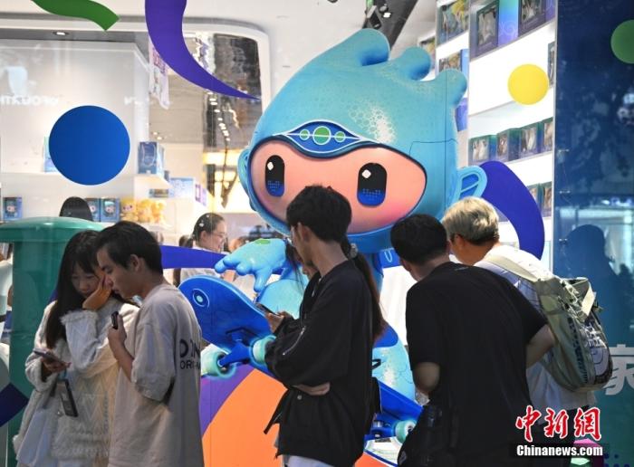 资料图：9月23日，杭州第19届亚运会开幕式在浙江杭州奥体中心体育场举行。图为游人在亚运特许商品店外排队购物。<a target='_blank' href='/'>中新社</a>记者王刚摄