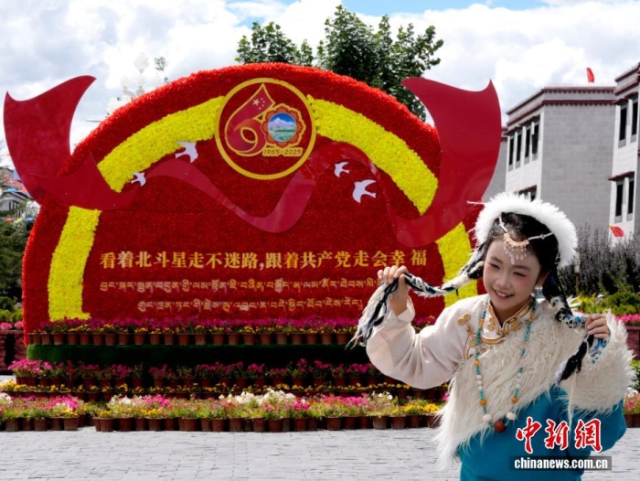 8月19日,随着西藏自治区成立60周年庆祝活动临近,拉萨氛围浓。拉萨街头,处处是张灯结彩的盛景,洋溢着一派祥和与欢腾的氛围。图为游客在拉萨大昭寺广场上的大庆宣传标语前留念。<a target='_blank' href='/'>中新社</a>记者李林摄