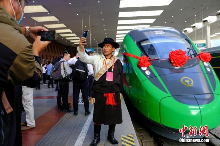 2021年6月25日,川藏铁路拉林段(拉林铁路)正式开通运营,复兴号高原内电双源动车组同步投入运营。拉林铁路全长48公里,设计时速160公里。这是西藏首条电气化铁路,也是复兴号动车组首次开进西藏。图为当日,民众在拉萨火车站复兴号车头前拍照留念。 <a target='_blank' href='/'>中新社</a>记者江飞波摄