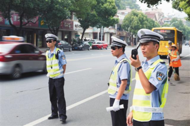 2015年7月17日,浙江桐庐,桐庐县城区中队交警,辅警手持抓拍设备在斑马