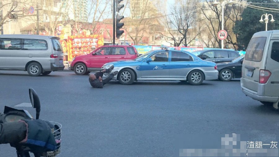 杭州一男子翘腿叼烟躺地上碰瓷出租车