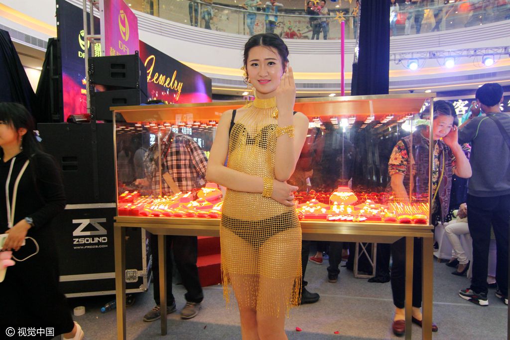 2016年4月10日,湖北省襄阳市,一名比基尼美女身穿黄金连衣裙走秀
