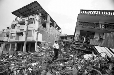 一名厄瓜多尔警察站在被地震摧毁的建筑废墟中。图/东方IC
