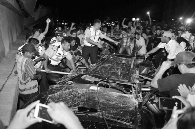 当地时间4月16日，在厄瓜多尔第一大城市瓜亚基尔，人们试图救出一名被断桥砸中困在车内的人。 新华社发