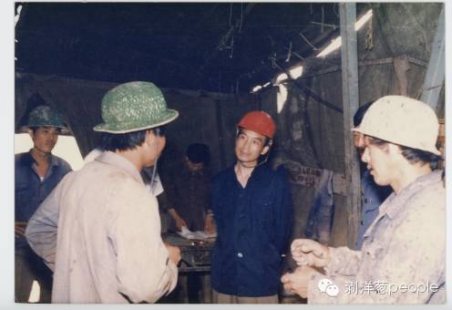 1985年7月，在辽宁锦西盘道沟金矿区调研时在机台与工人交谈。图片来源：地质出版社