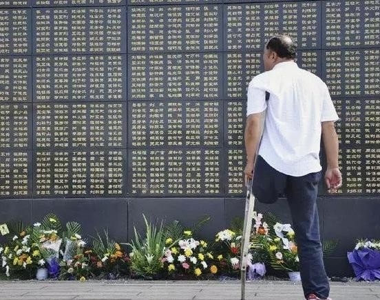 一位男士在唐山大地震纪念墙前追思亲人