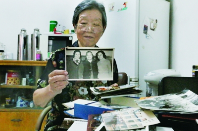 叶梅娟向记者展示其和康克清的合影，老照片中间者为康克清，左为叶梅娟