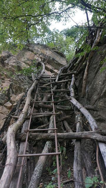 组图：绝壁修路 村民背1500根钢管上山造天梯