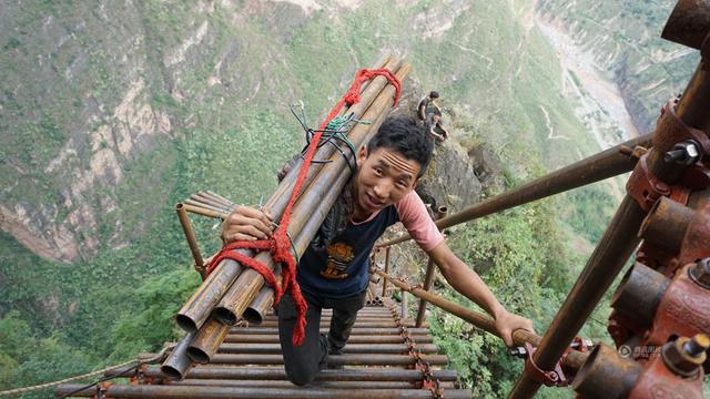 组图：绝壁修路 村民背1500根钢管上山造天梯