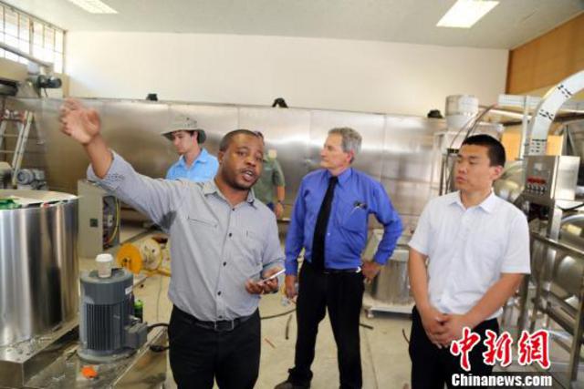 工作人员介绍中国—南非农业技术示范中心正在建设中的饲料加工车间。　宋方灿 摄