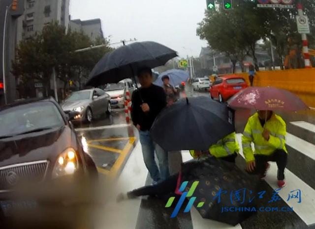 女子雨中被撞倒地 民警为其撑伞遮雨