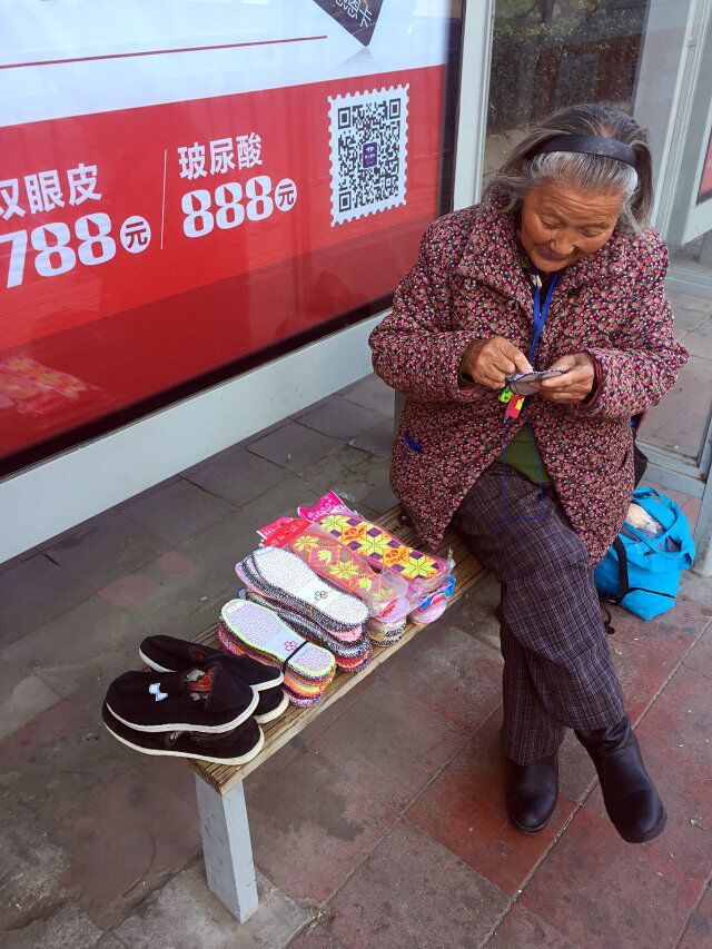 八旬老太车站卖鞋垫儿 不为赚钱只是闲不住