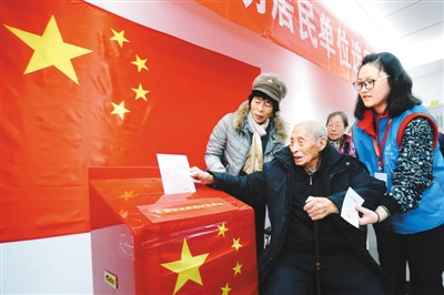 百岁老人冯乃光在家人的陪伴下，来到北京市东城区光明选区投票站投下自己的一票。