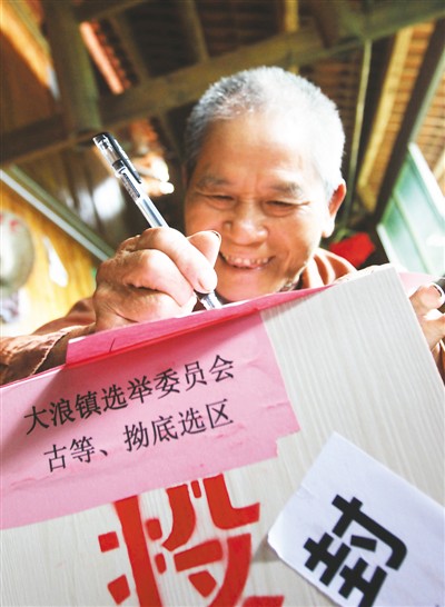 在广西融水苗族自治县大浪镇古等壮寨，一名壮族选民在填写选票。