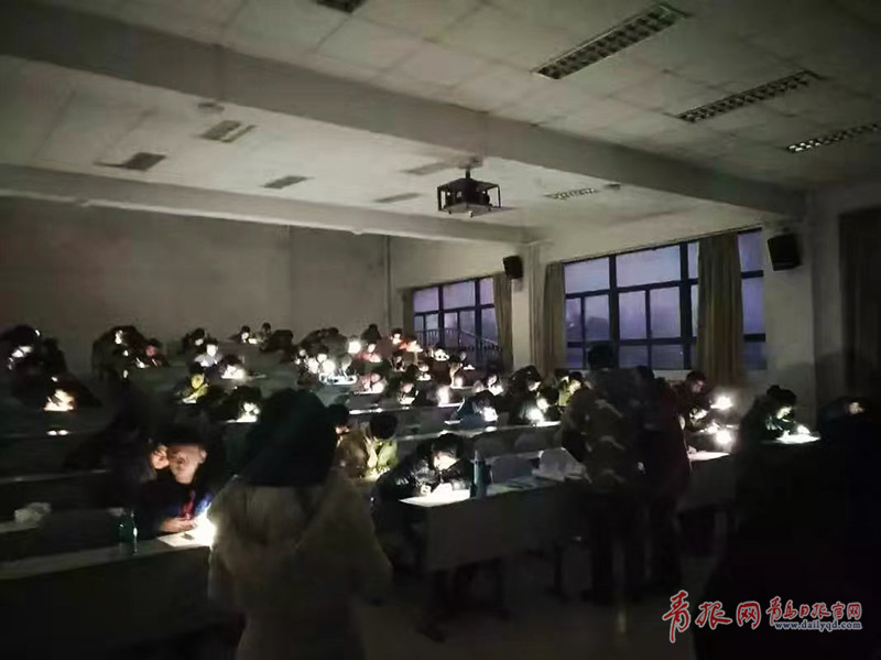 青岛一高校停电 考生在手机灯光下答卷