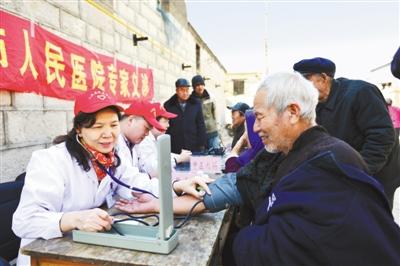 河北邢台市人民医院的医务志愿者组成爱心医疗小分队，为太行山区的留守、孤寡老人义诊。图为3月19日，医生正在为村里老人测量血压。
