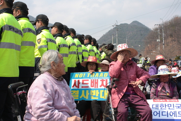 3月29日白天，村里的奶奶们坐在卡车欲经过的道路上。