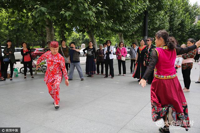 2017年5月15日,西安,70后石荣穿着漂亮的花衣服高跟鞋教大妈们跳新疆