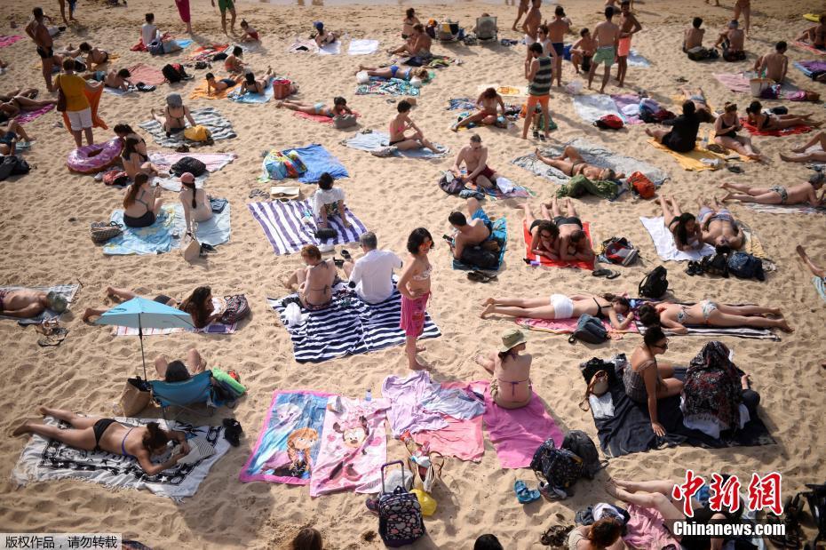 西班牙海滩游人扎堆 “玉体横陈”晒日光浴