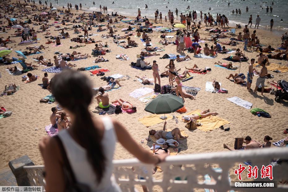 西班牙海滩游人扎堆 “玉体横陈”晒日光浴