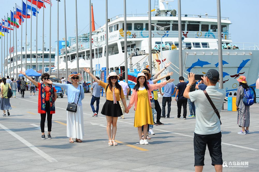 青岛重回24℃ 海边女游客大秀清凉