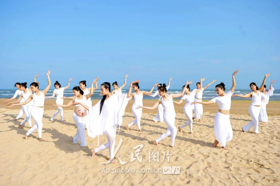  青岛瑜伽爱好者来到海边沙滩，在沙滩和海水中秀起瑜伽。