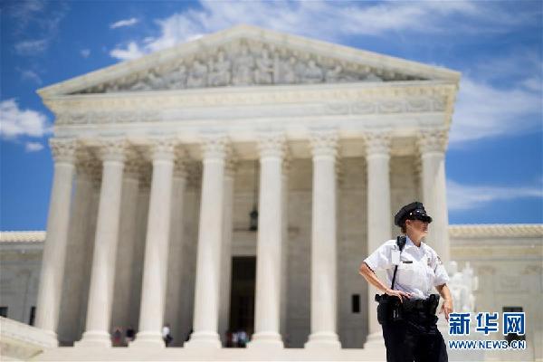     6月26日,在美国华盛顿,警察在最高法院门口执勤。美国最高法院26日部分解冻特朗普政府新版移民限制令,并表示将在今年10月正式审理移民限制令是否合法一案。