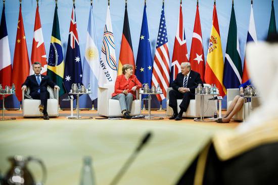 资料图：7月7日，在德国汉堡，阿根廷总统马克里、德国总理默克尔和美国总统特朗普出席G20领导人峰会。新华社发