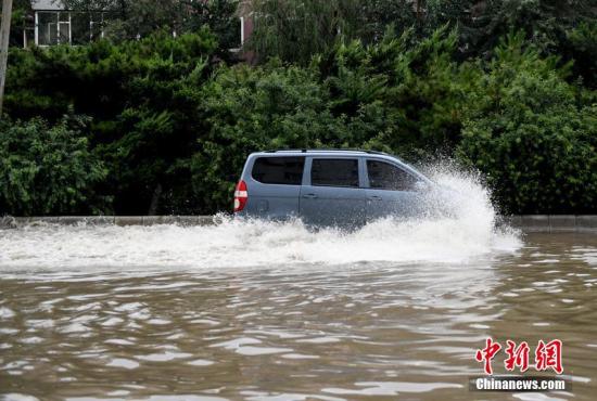 7月16日，长春迎来暴雨天气，市区多处出现内涝积水。图为车辆在水中行驶。