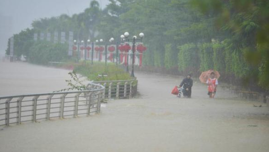 台风“电母”来袭，海南省临高县市民冒险在洪水淹没的江堤行走