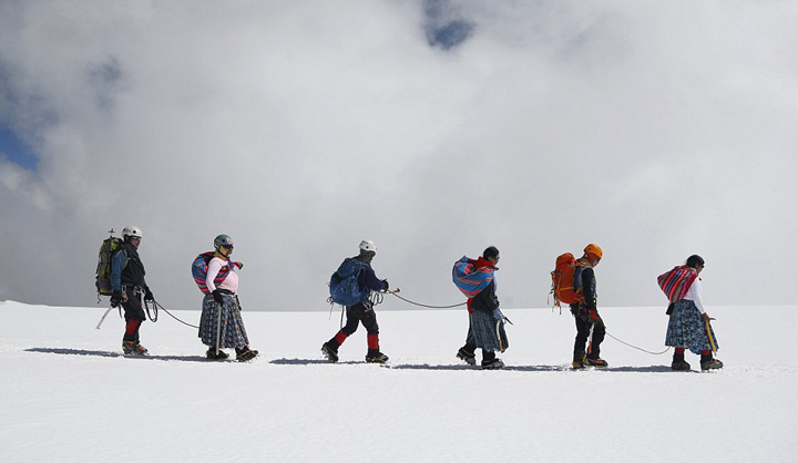 玻利维亚女性穿传统服饰助登山者攀登