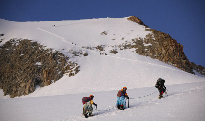 玻利维亚女性穿传统服饰助登山者攀登