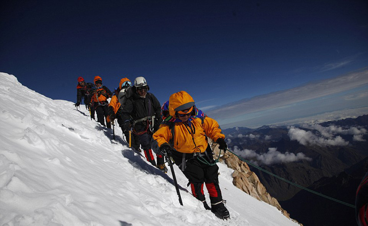 玻利维亚女性穿传统服饰助登山者攀登