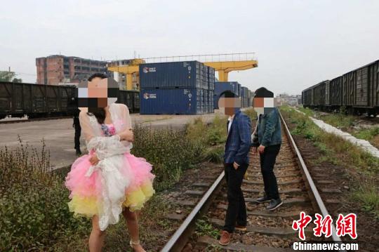 新人在铁轨上拍婚纱照逼停火车被警方处罚（图）