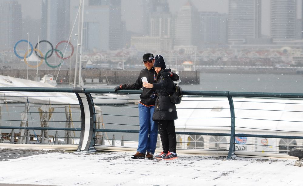 高清：青岛情侣狂风中秀恩爱 无惧大雪纷飞