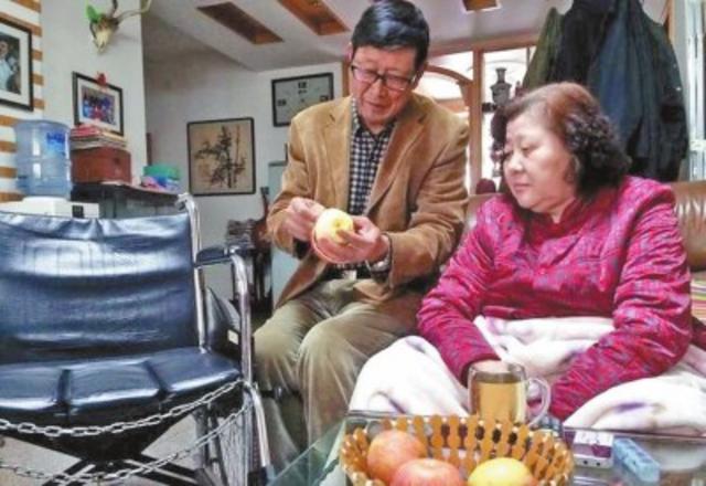 袁敏智老人给轮椅上的老伴削苹果