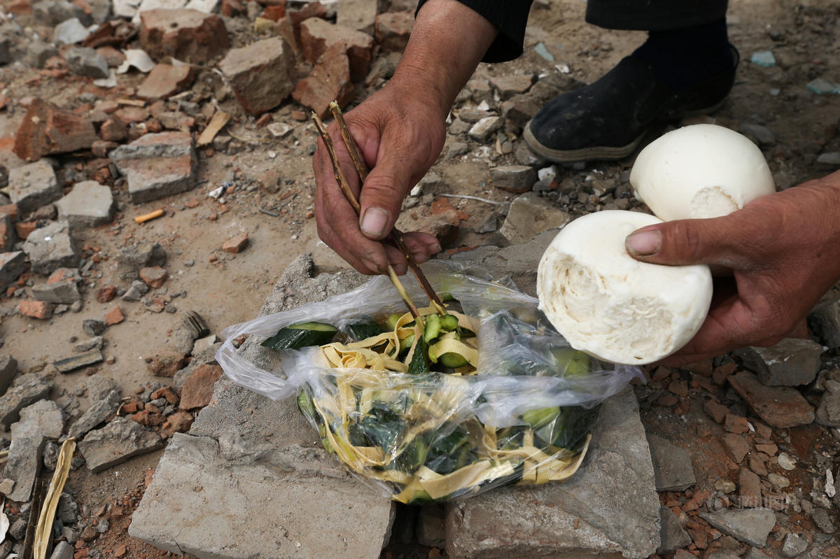 组图：实拍工地民工午饭 塑料袋盛饭树枝当筷