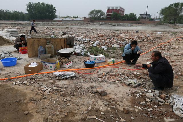 组图：实拍工地民工午饭 塑料袋盛饭树枝当筷