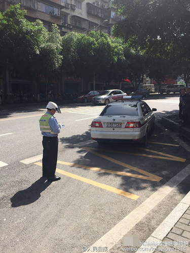 交警在对违停的警车开罚单