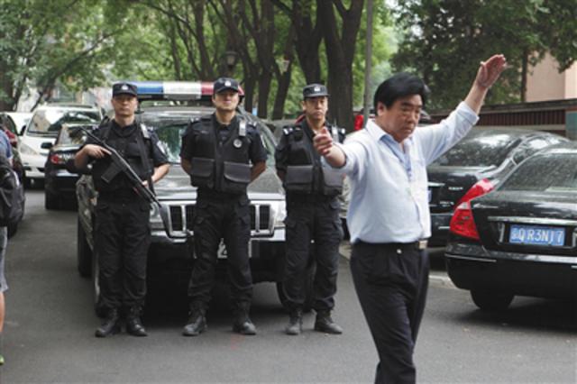 海淀区教育招生和考试中心门口特警站岗,工作人员指挥取卷车辆。新京报记者 王嘉宁 摄